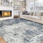 Aelenmu 8x10 blue and grey abstract area rug on a wooden floor, enhancing a modern living room.