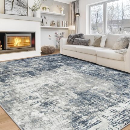 Aelenmu 8x10 blue and grey abstract area rug on a wooden floor, enhancing a modern living room.