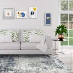 Aelenmu 8x10 blue and grey abstract area rug on a wooden floor, enhancing a modern living room.