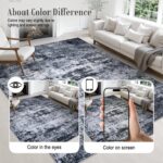 A black 5x7 modern abstract area rug with subtle patterns, laid out in a living room setting.