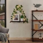 A set of two JOPSTDI White Flower floating triangle shelves with artificial ivy and LED lights, mounted on a wall.