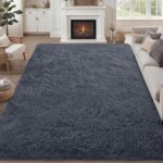 A soft, plush grey 8x10 shag area rug from Luxturiy, laid out in a modern living room setting.