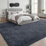 A soft, plush grey 8x10 shag area rug from Luxturiy, laid out in a modern living room setting.