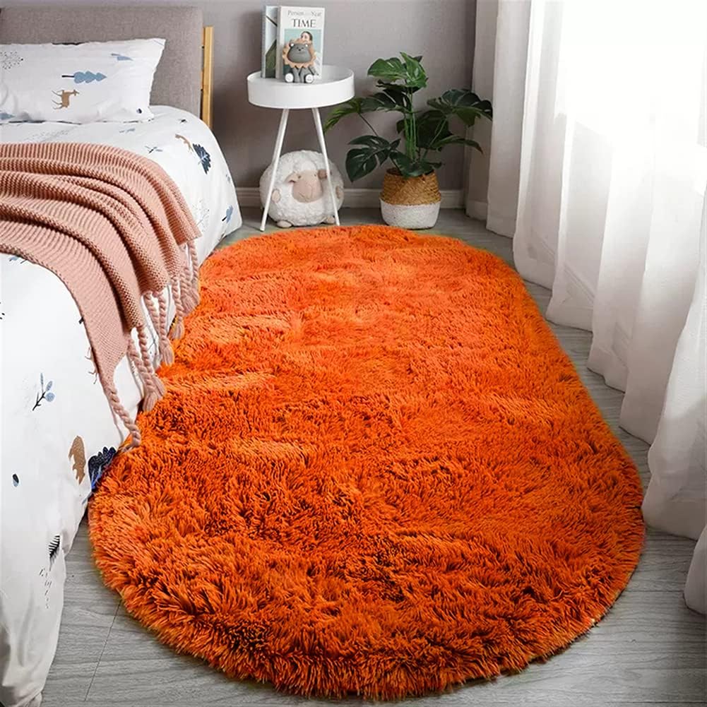 reyox-orange-oval-fluffy-area-rug-24-x-35-handmade-high-pile-polyester-carpet-01 An orange oval fluffy area rug with a high pile texture, perfect for a living room or bedroom floor.