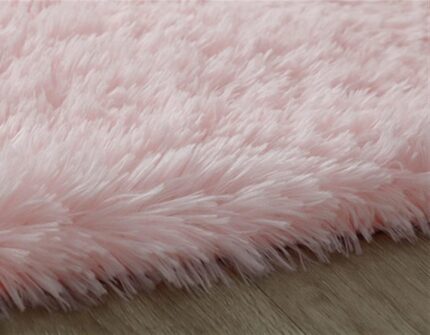 An orange oval fluffy area rug with a high pile texture, perfect for a living room or bedroom floor.