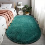 An orange oval fluffy area rug with a high pile texture, perfect for a living room or bedroom floor.