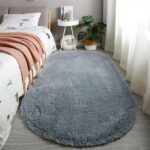 An orange oval fluffy area rug with a high pile texture, perfect for a living room or bedroom floor.