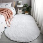 An orange oval fluffy area rug with a high pile texture, perfect for a living room or bedroom floor.